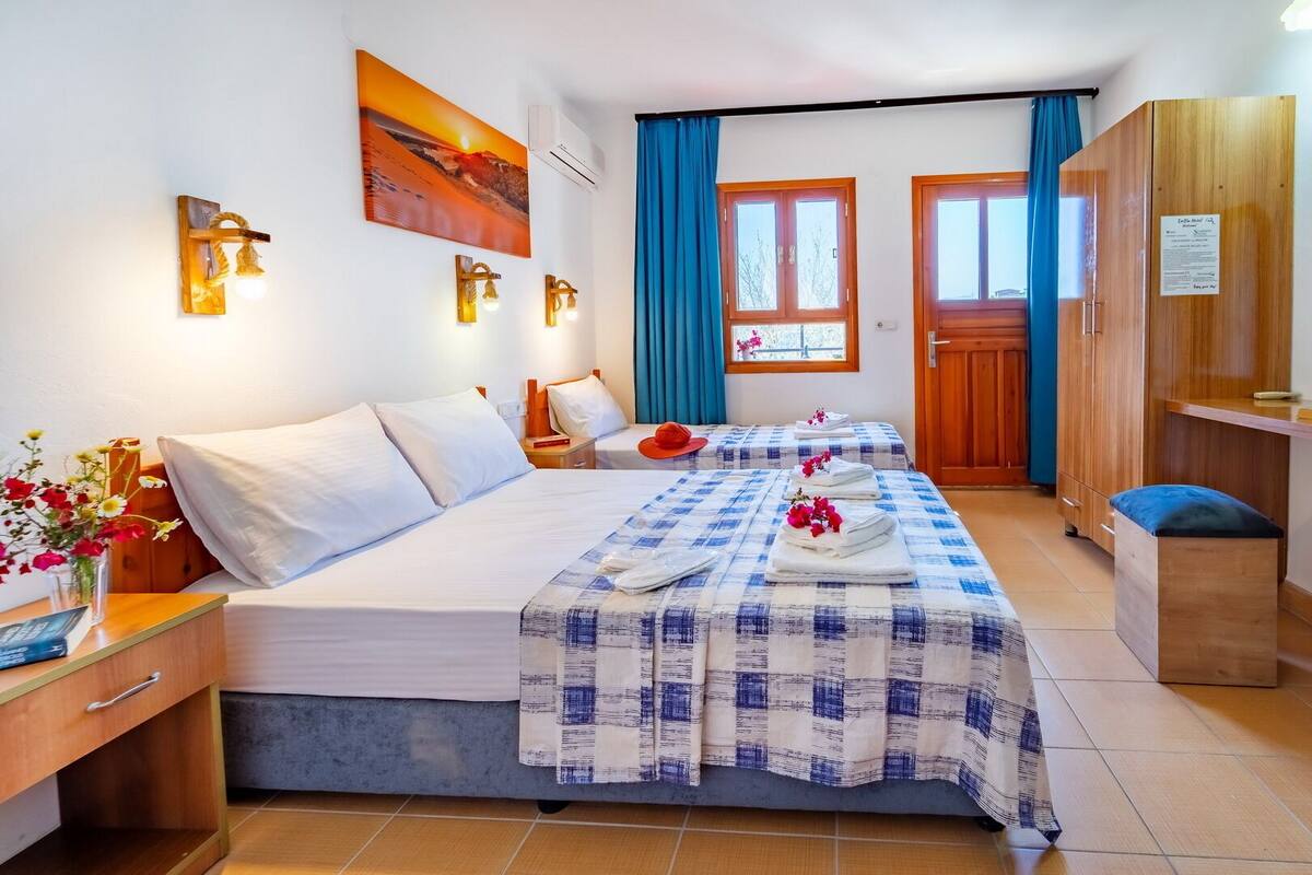 A hotel room with a large bed, a desk, a wardrobe, and a bathroom.