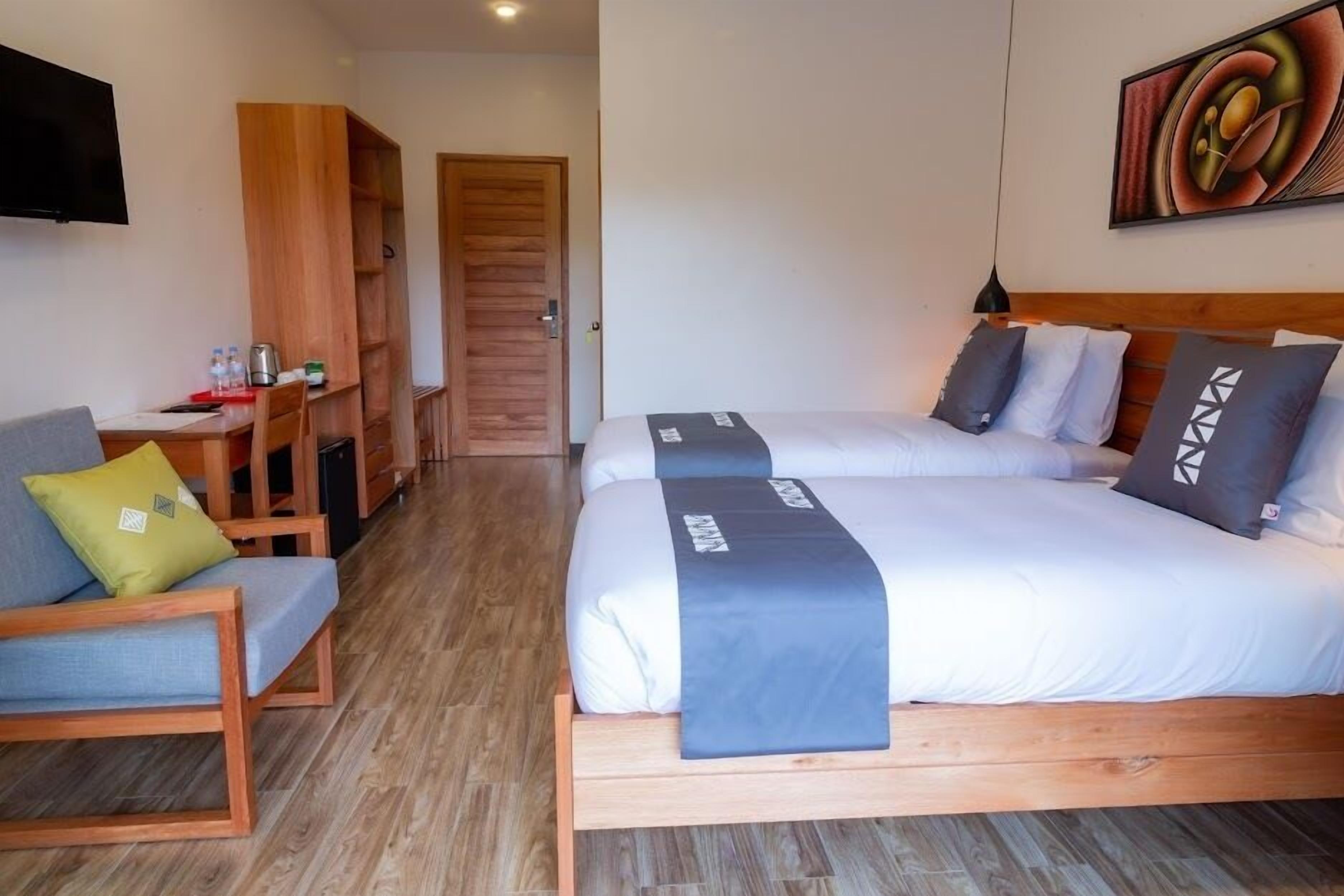 A hotel room with a bed, a desk, and a chair.