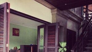 An open-plan living area with a dining table and chairs, a staircase, and a view of the interior. - Ancient Luang Prabang Hotel (Luang Prabang)