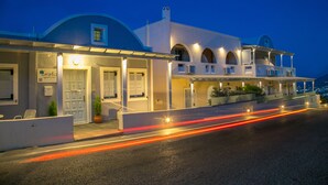 Un hotel moderno con tetto curvo, numerosi balconi e un ingresso ben illuminato.