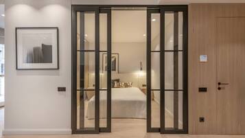 A hotel room with a bed, a wardrobe, and a sliding door leading to the bathroom.