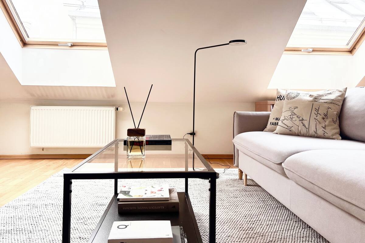 A modern living room with a glass coffee table, a sofa, and a radiator.