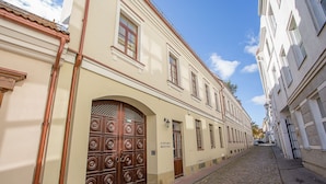 Un edificio histórico con una puerta de madera grande y un letrero que dice "KIRPIMO MEISTRIA".