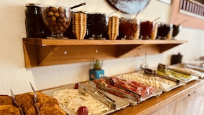 A buffet with various food items and condiments on wooden shelves. - Bozcaada Hotel Vitis (Bozcaada)