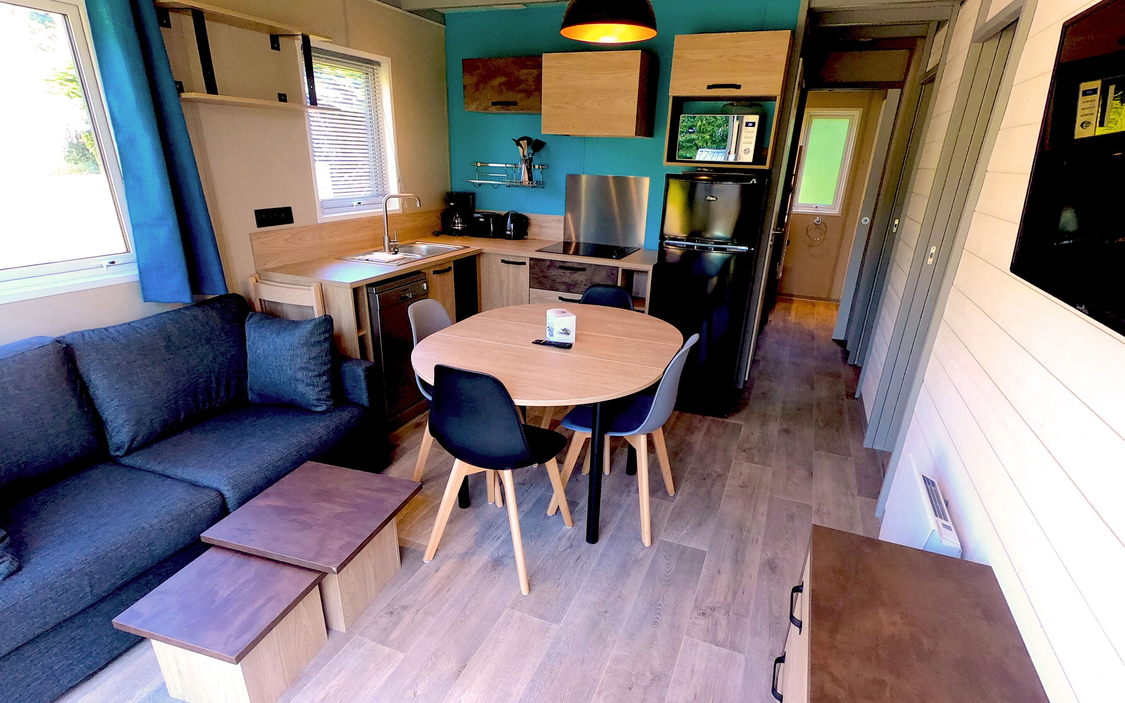A compact kitchenette with a microwave, stove, and sink.