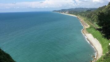 A coastal landscape with a clear view of the sea and a beach.