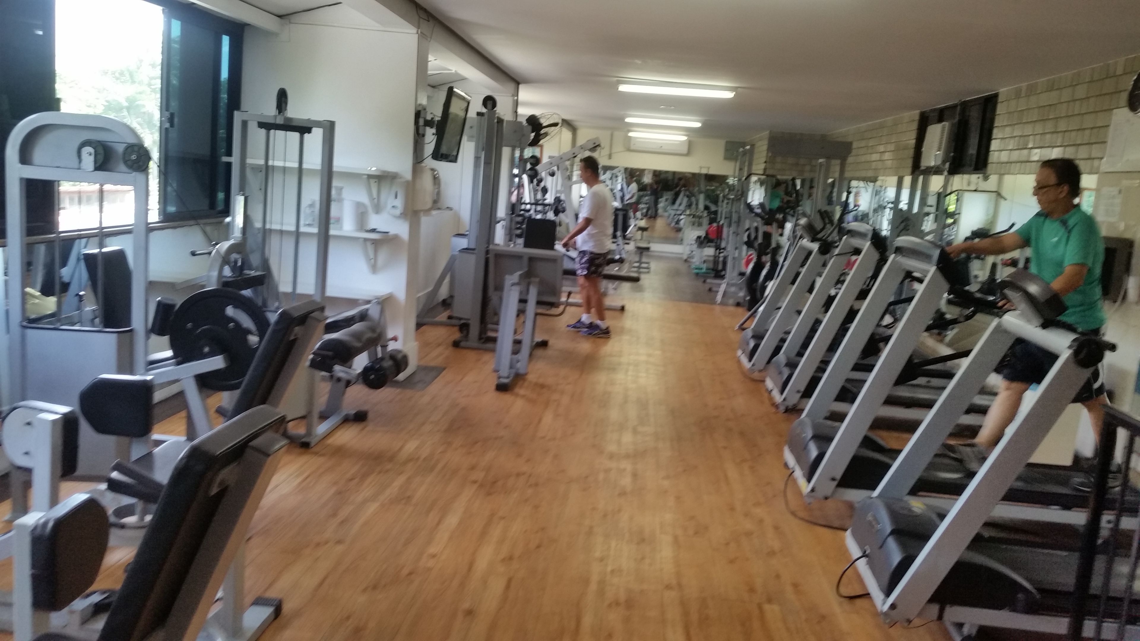 Un gimnasio con equipo de ejercicio variado, incluyendo cintas de correr y máquinas de pesas.