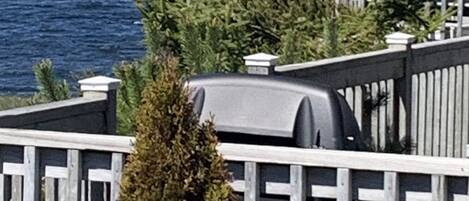 Una terraza de madera con un pabellón que da a un cuerpo de agua.