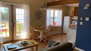 Un espacio habitable pequeño con comedor, sofá y kitchenette.