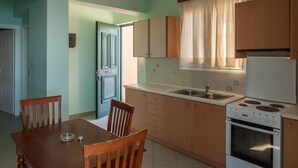 A kitchen with wooden cabinets, a sink, and a stove. - Epidavros Seascape (Epidaurus)