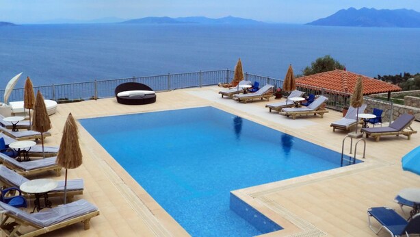 A pool area with sun loungers, umbrellas, and a view of the sea. - Epidavros Seascape (Epidaurus)