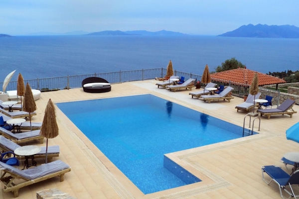 Una piscina al aire libre de temporada, sombrillas, tumbonas