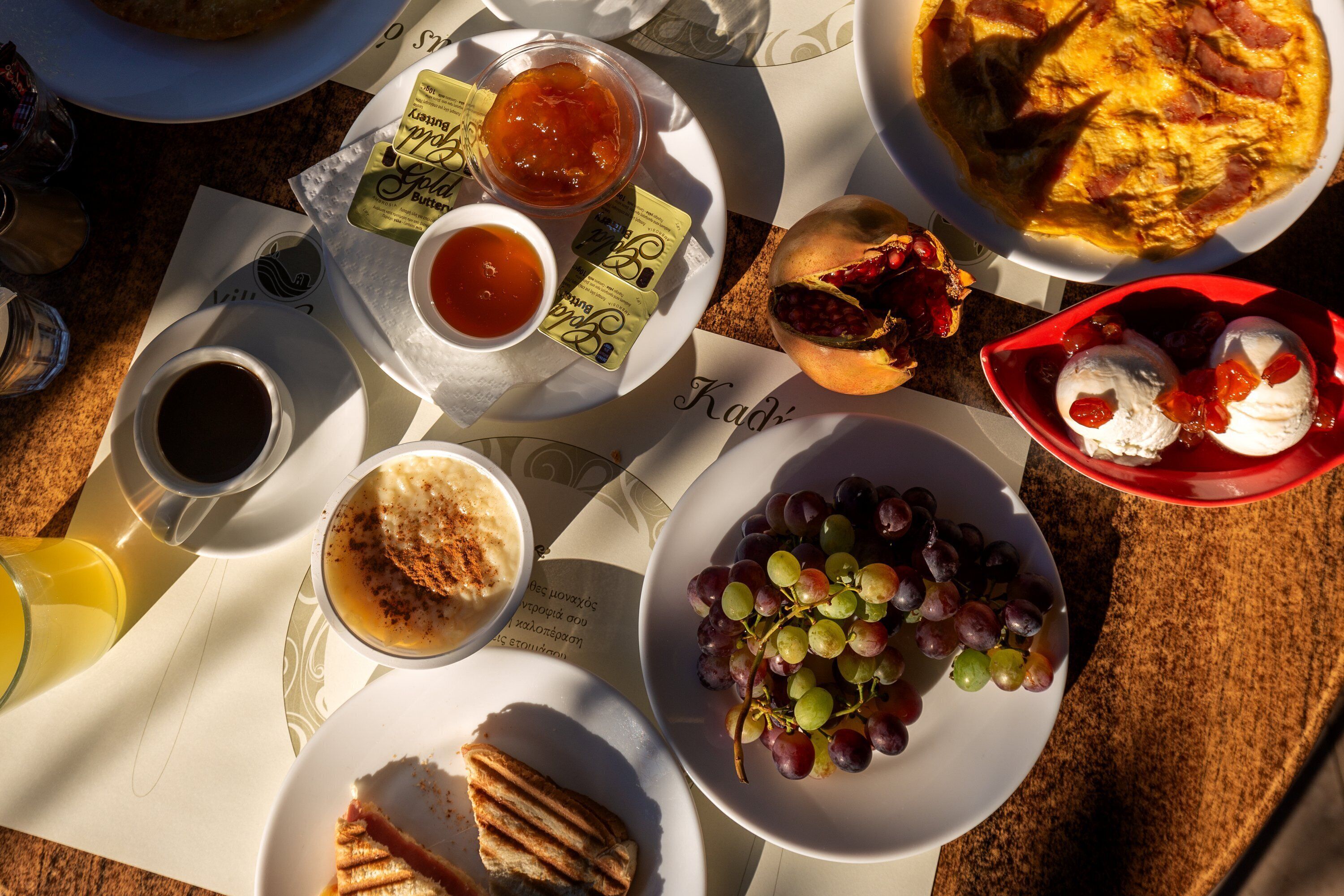 A breakfast setting with various food items and beverages on a table.