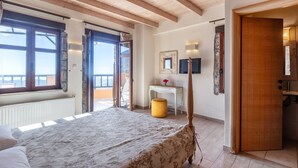 Un dormitorio con una cama grande, un escritorio y un armario.