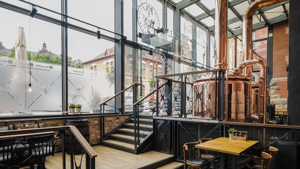 A modern interior with a staircase, wooden flooring, and a view of the city through large windows. - Craft Beer Central Hotel (Gdansk)