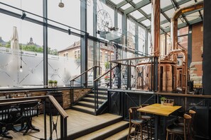 Een modern interieur met een trap, houten vloeren en een uitzicht op de stad door grote ramen.