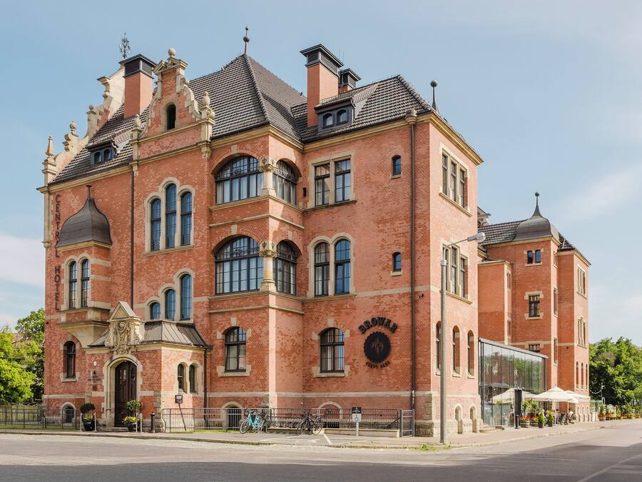 A large, historic brick building with arched windows and a prominent entrance.