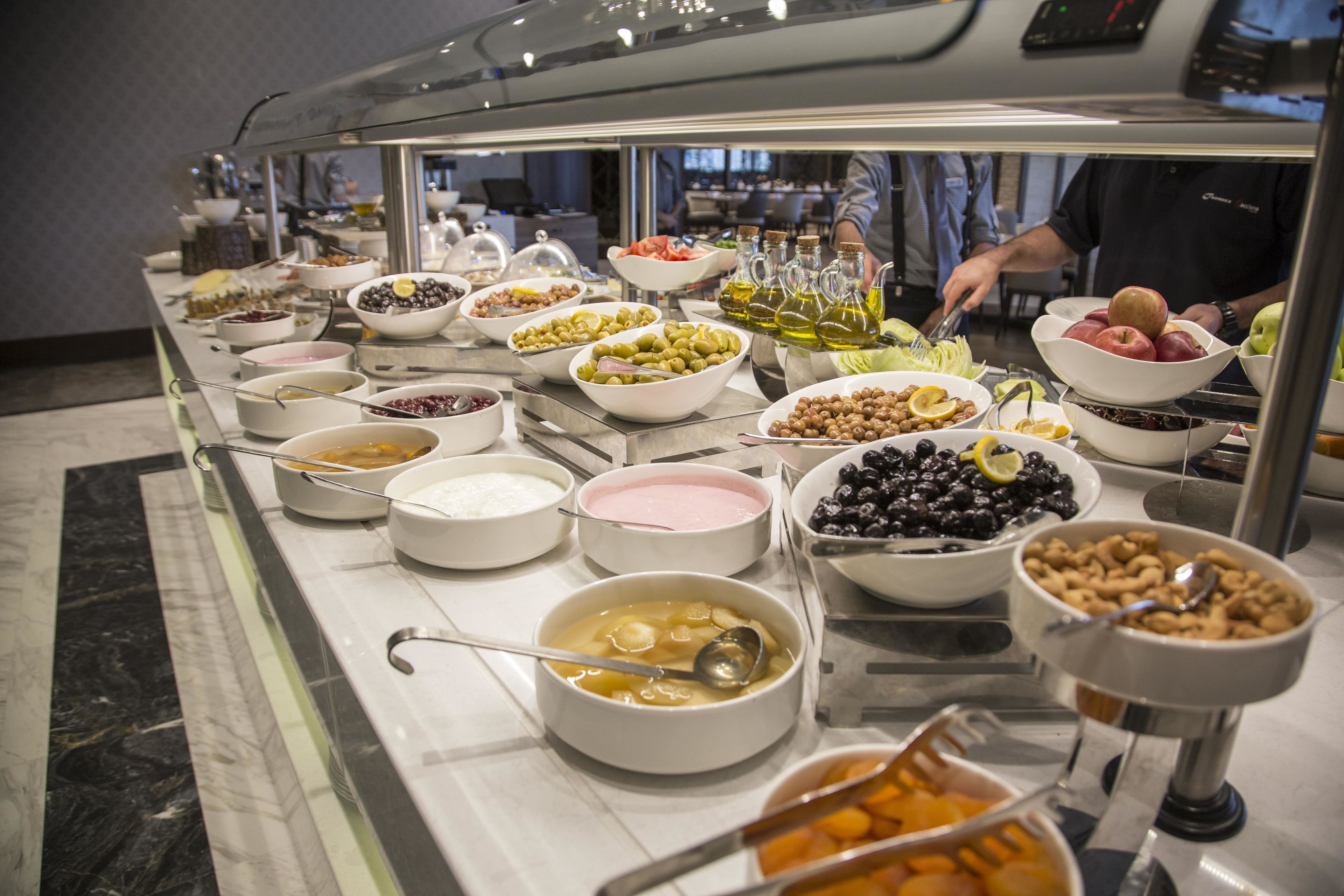 A buffet with various food items including fruits, nuts, and dips.