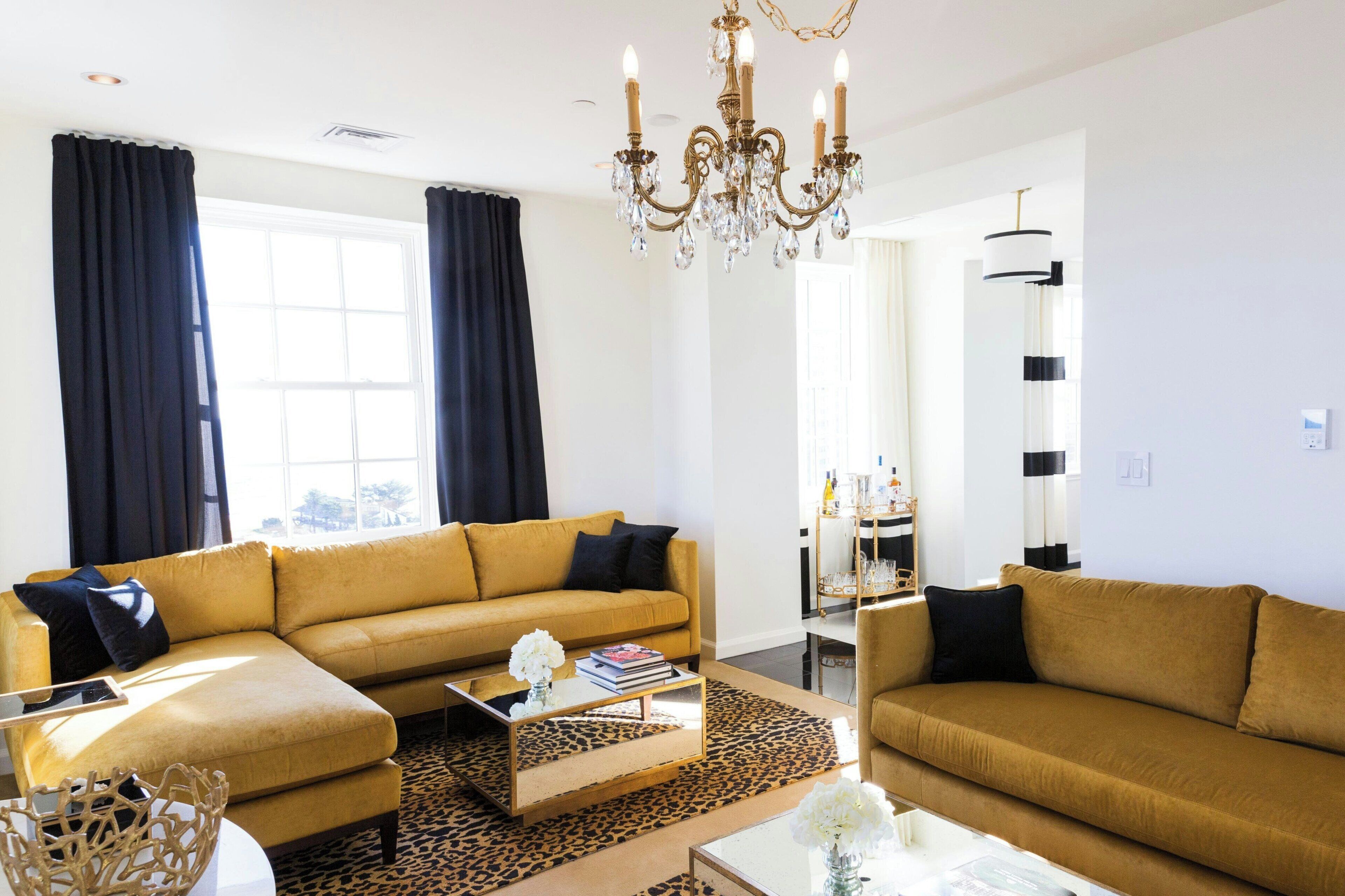 Ett modernt vardagsrum med två soffor, ett soffbord och en kristallkrona.
