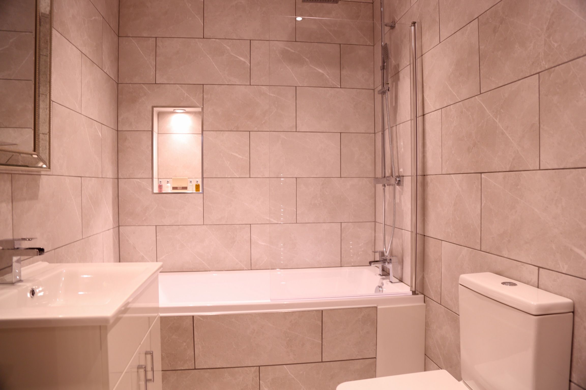 A modern bathroom with a bathtub, a sink, and a toilet.