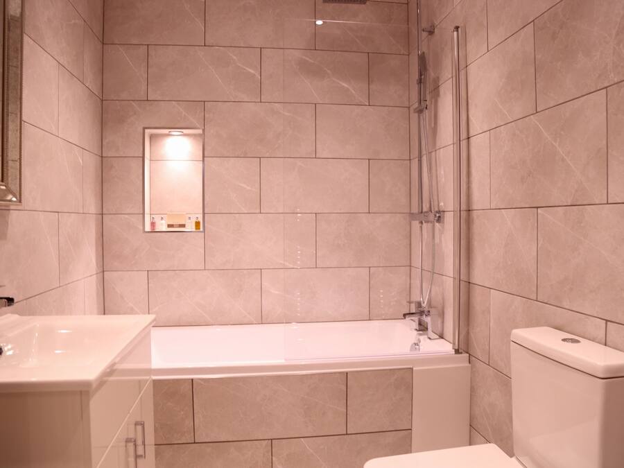 A modern bathroom with a bathtub, a sink, and a toilet.