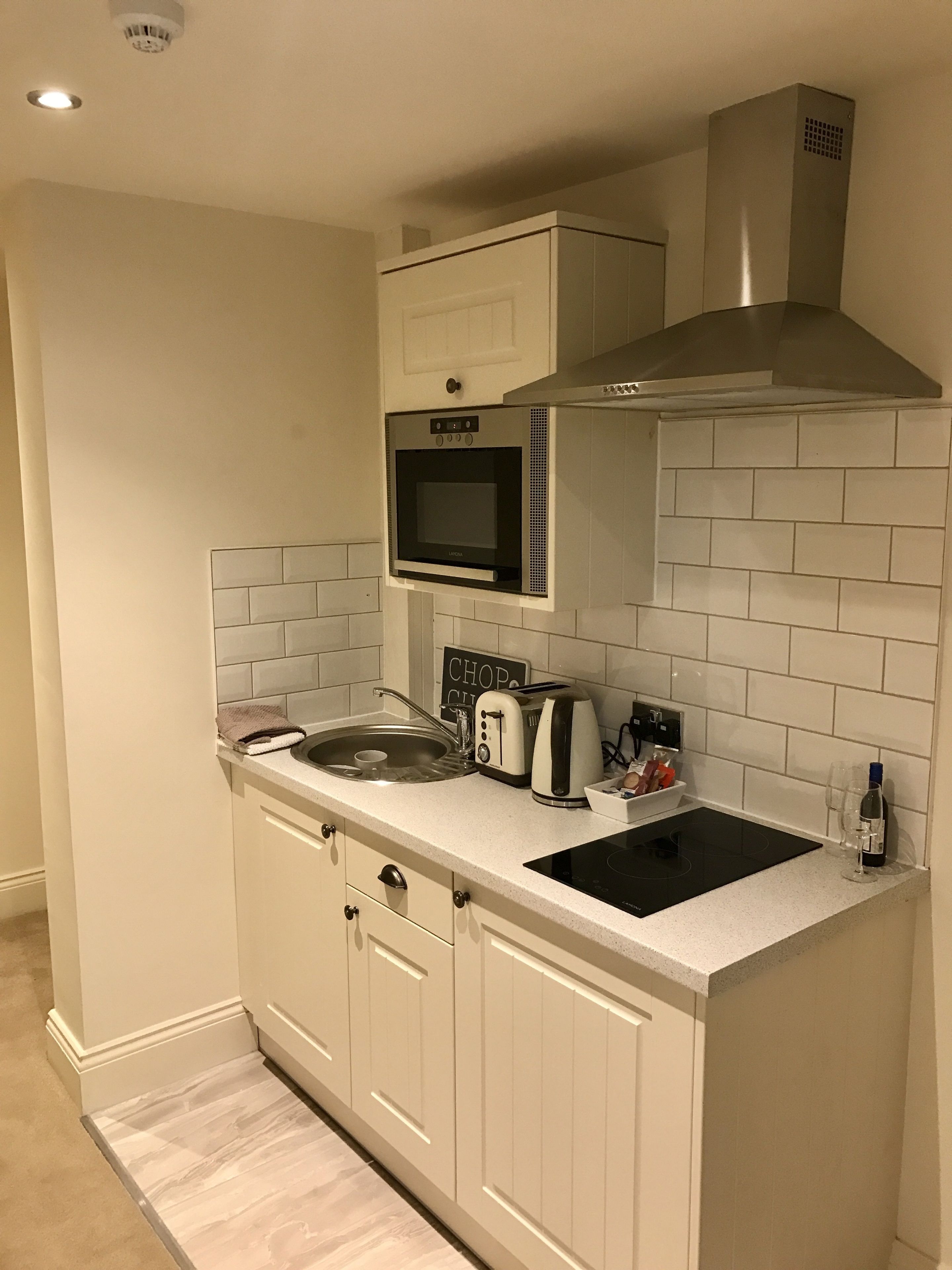 Una cucina compatta con forno a microonde, tostapane e lavello integrati.