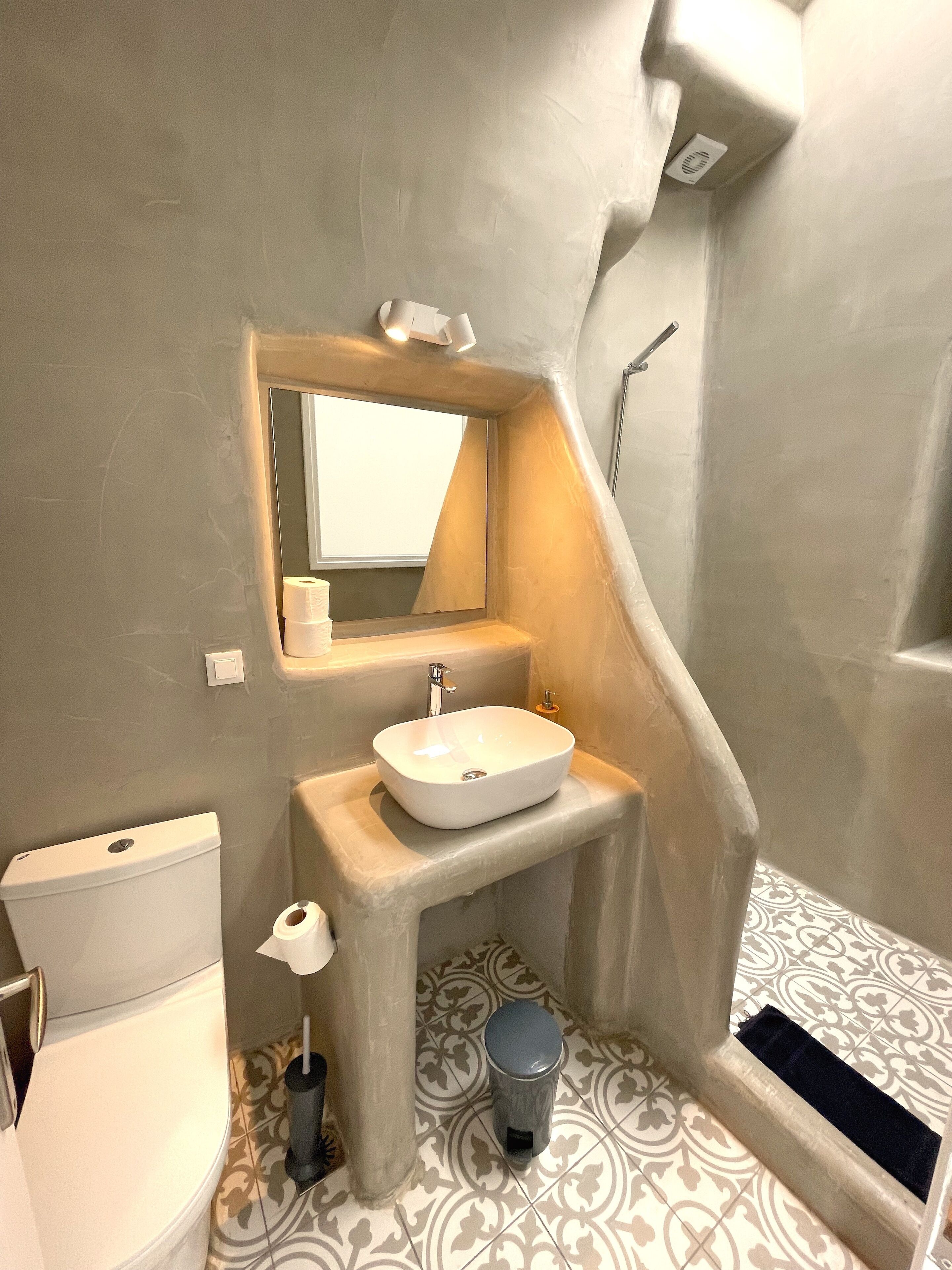 Un baño con lavamanos blanco, inodoro y ducha.