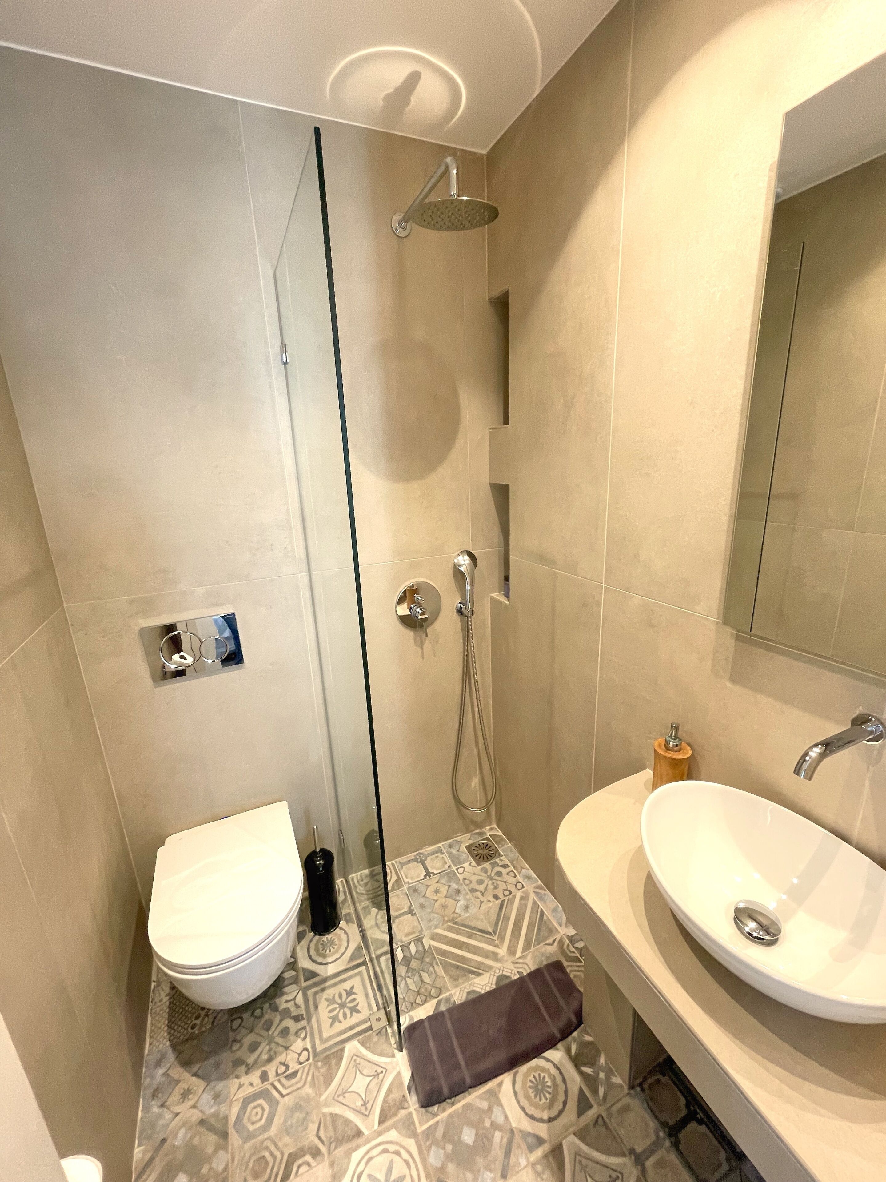 A bathroom with a shower, toilet, and sink.