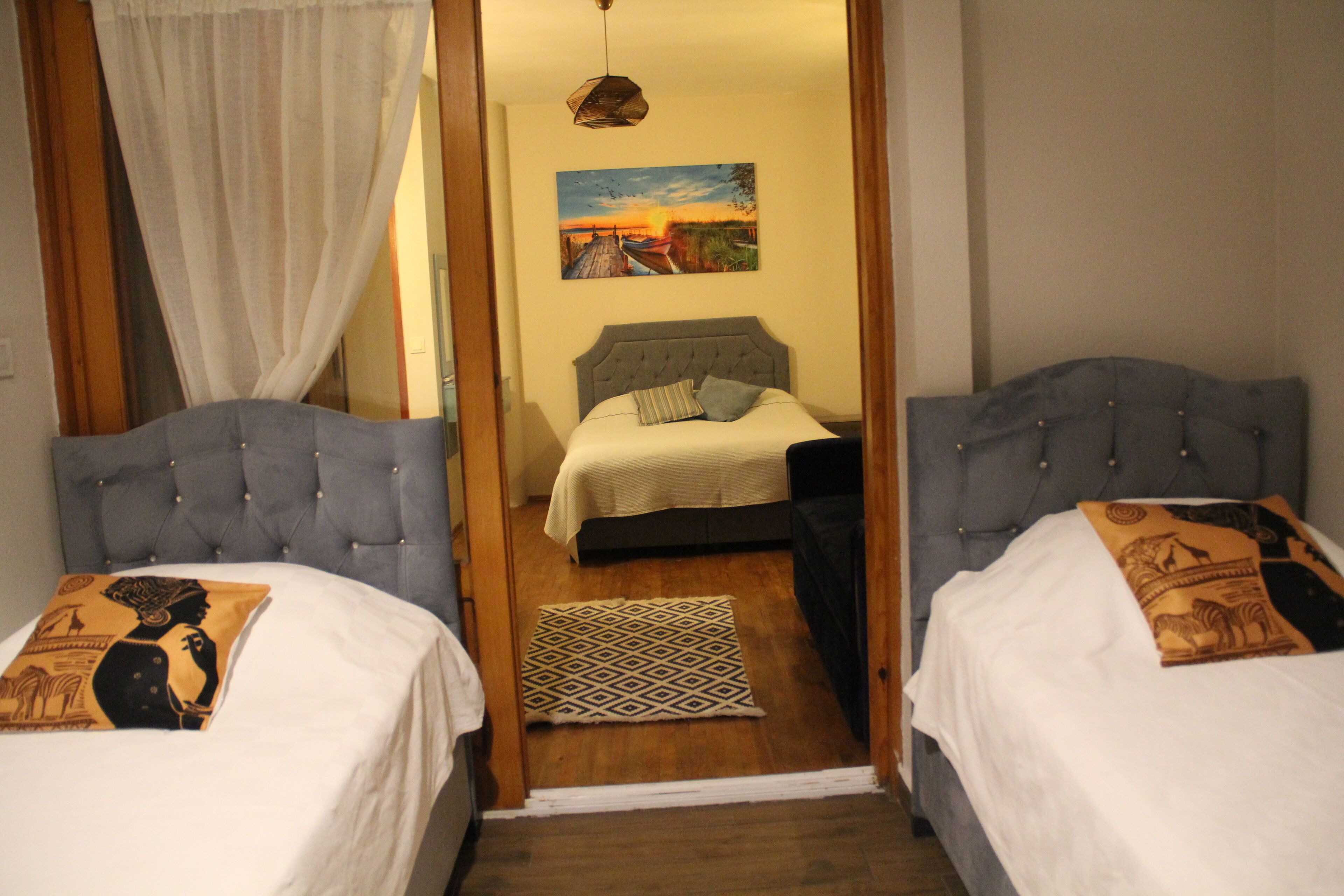 Una habitación con dos camas, un cuadro en la pared y un tapete estampado en el suelo.