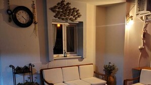 A cozy living room with a sofa set, wooden coffee table, and a window with curtains. - Balım Sultany (Cesme)
