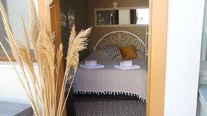 A bedroom with a bed, pillows, and a bedside table. - Balım Sultany (Cesme)