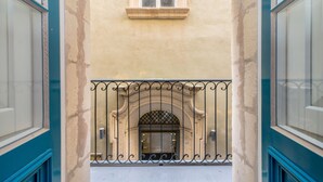 Une façade d’immeuble avec une entrée centrale en arc de cercle, flanquée de deux grandes portes vitrées.