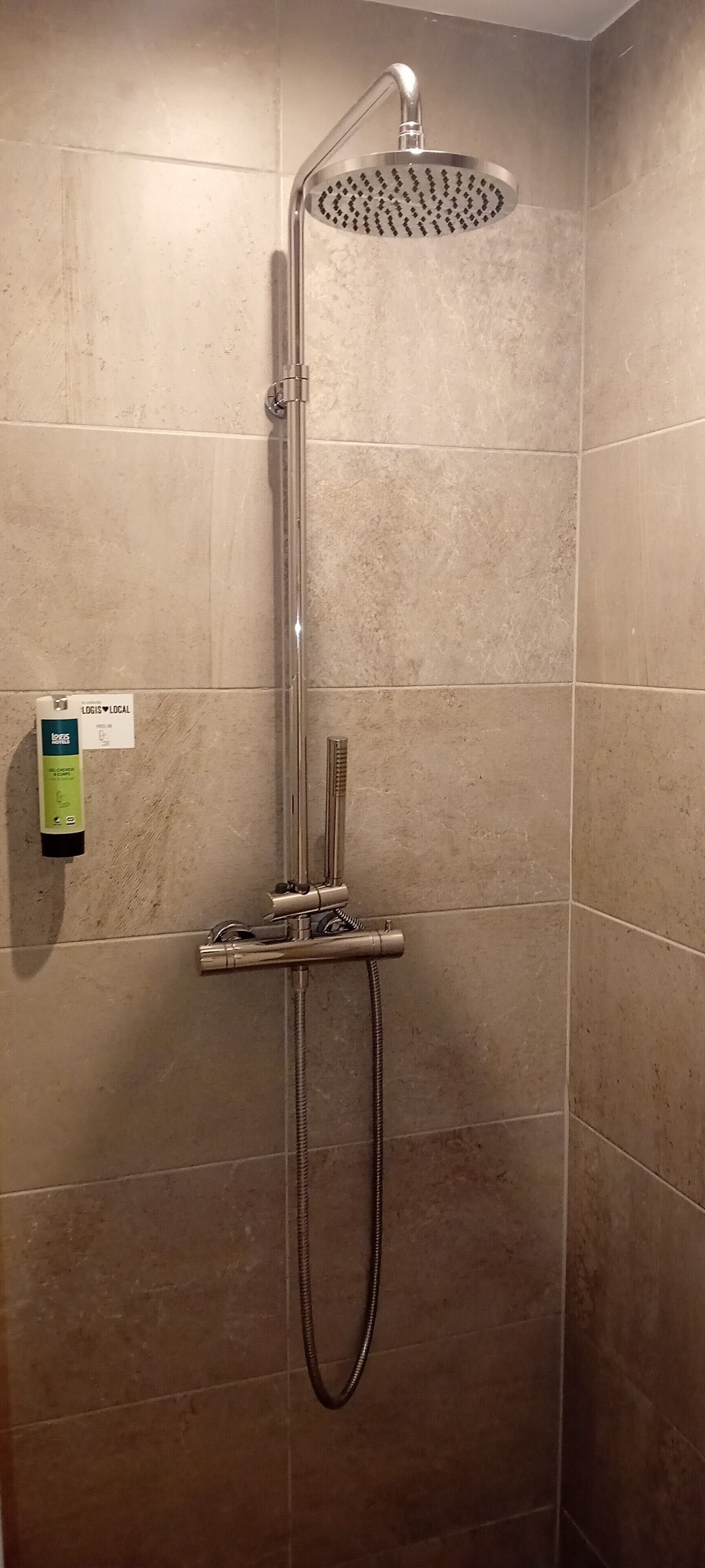 A shower with a handheld showerhead and a handheld hose.