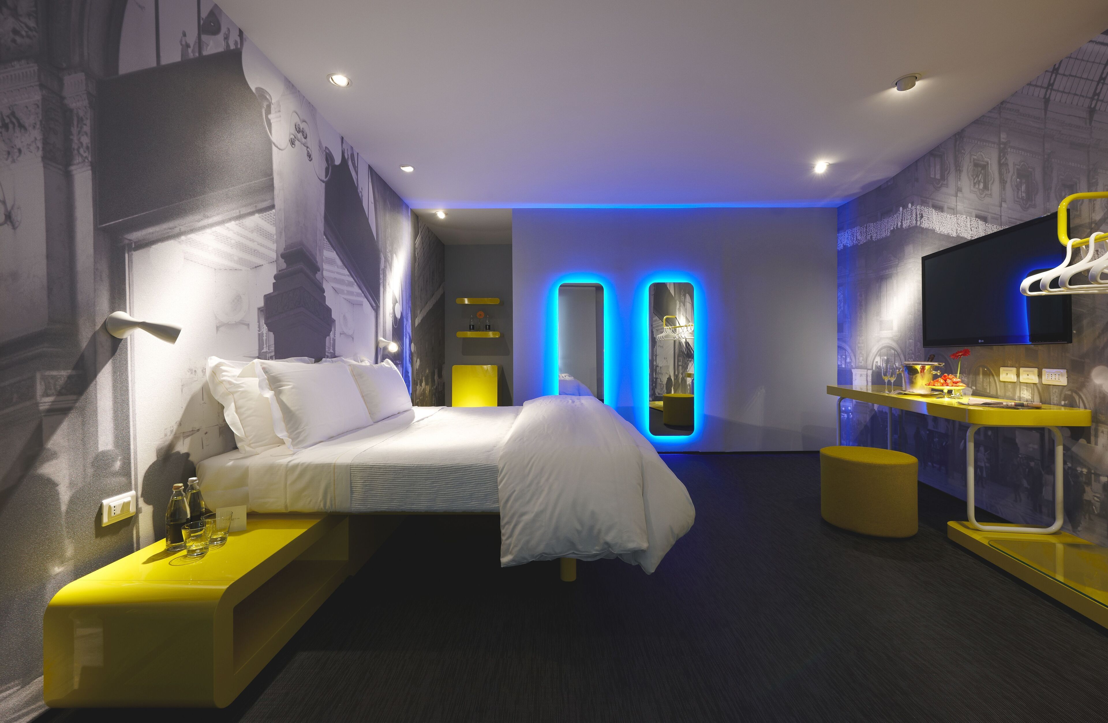 Une chambre d’hôtel moderne équipée d’un lit, d’une table de chevet et d’un téléviseur.