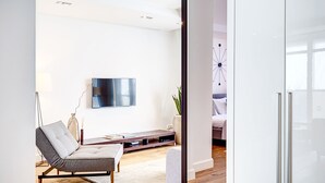 Una sala de estar moderna con un sofá, un televisor de pantalla plana, una mesa de centro y una planta decorativa.