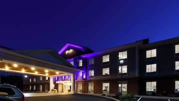 A hotel with a flat roof, multiple windows, and a sign indicating it is a Holiday Inn Express & Suites.
