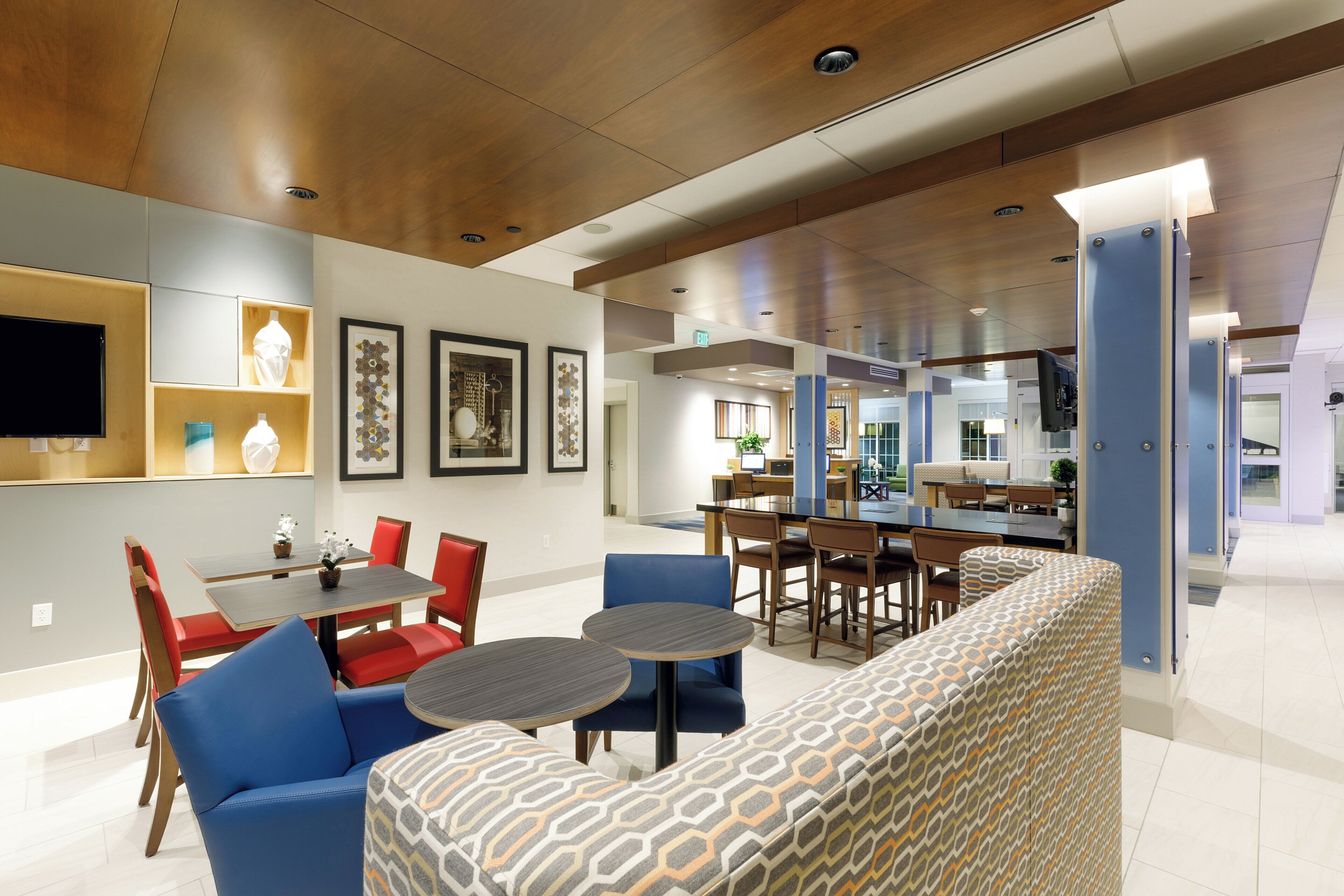 A modern interior with a dining area, seating, and a kitchen in the background.
