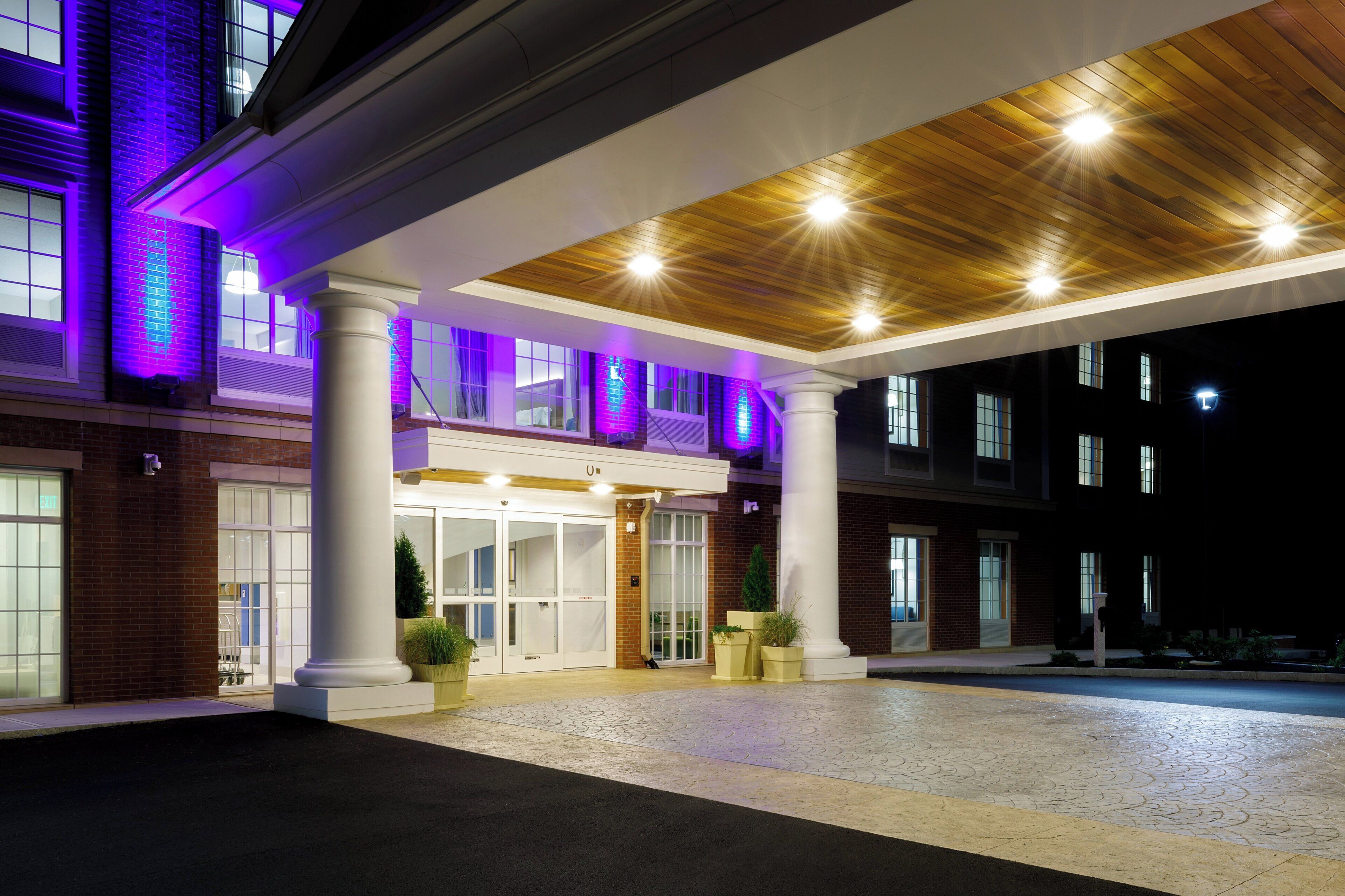 A hotel entrance with a covered walkway, columns, and a brick facade.