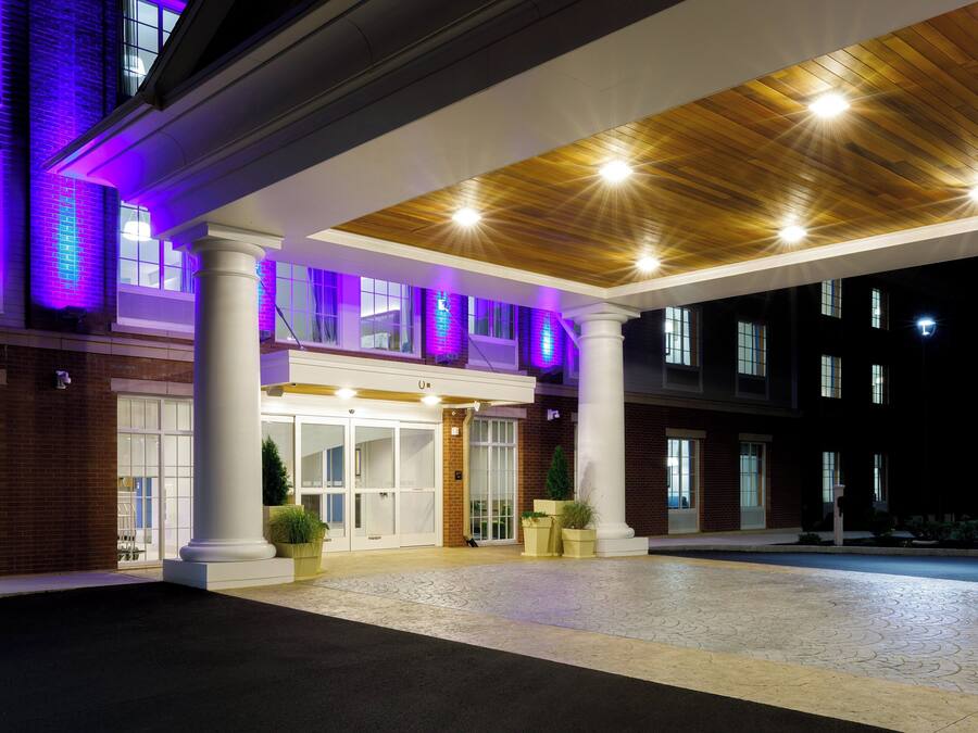 A hotel entrance with a covered walkway, columns, and a brick facade.