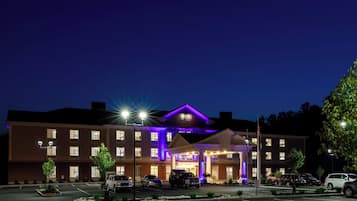 A multi-story hotel with a prominent entrance and a parking lot.