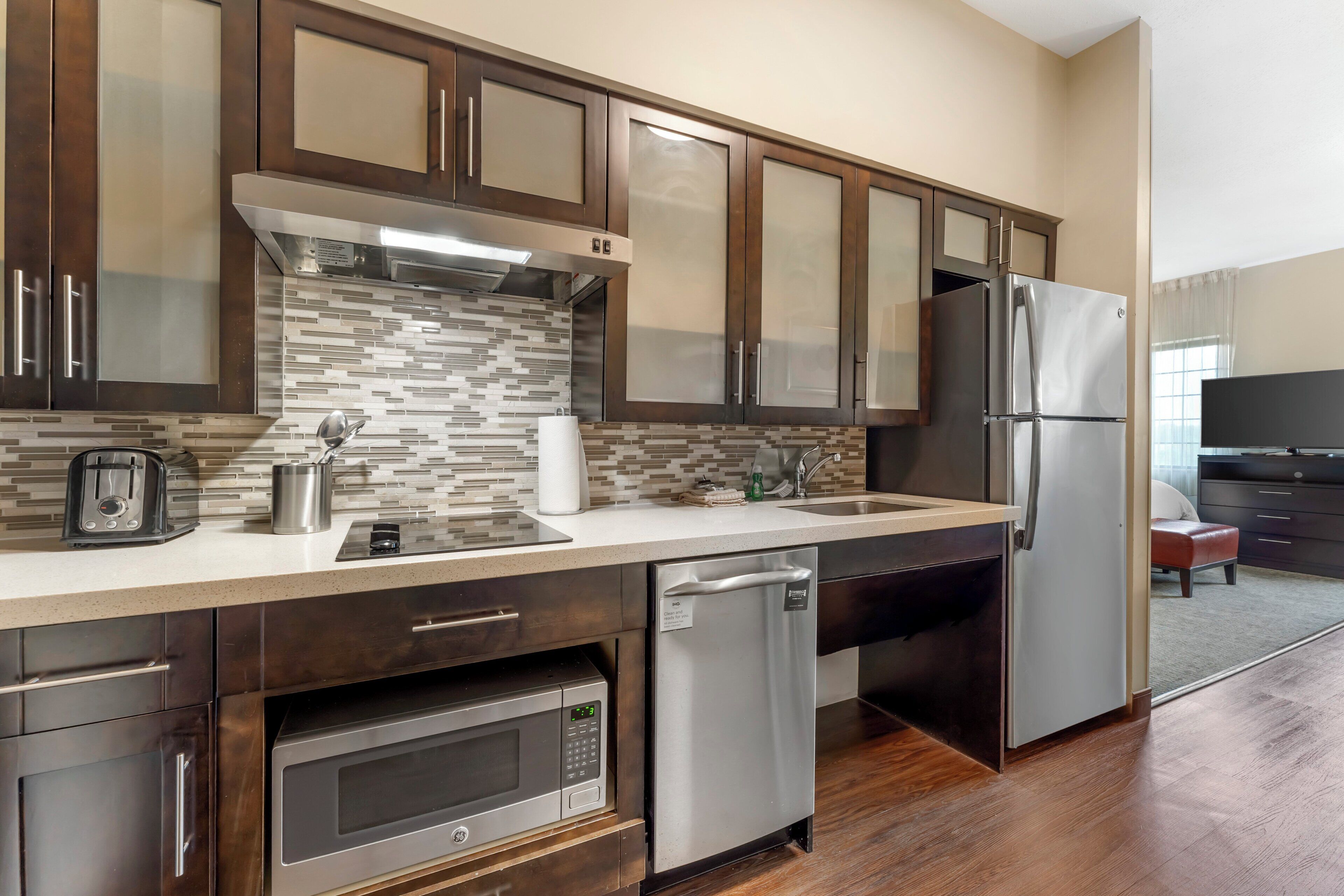 A modern kitchen with stainless steel appliances, a dishwasher, and a microwave.