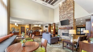 A hotel lobby with a fireplace, seating areas, and a reception desk. - Staybridge Suites Pittsburgh-Cranberry Township by IHG (Warrendale)