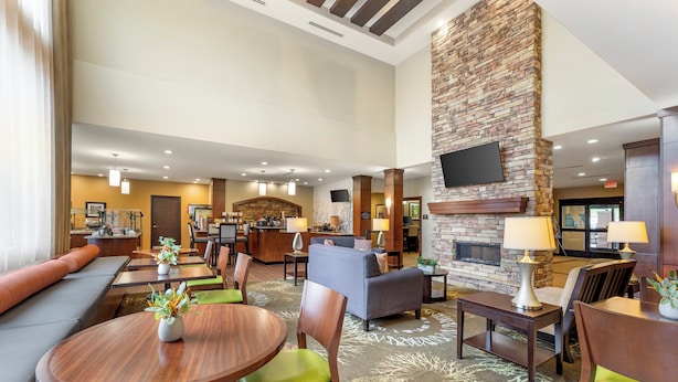 A hotel lobby with a fireplace, seating areas, and a reception desk.