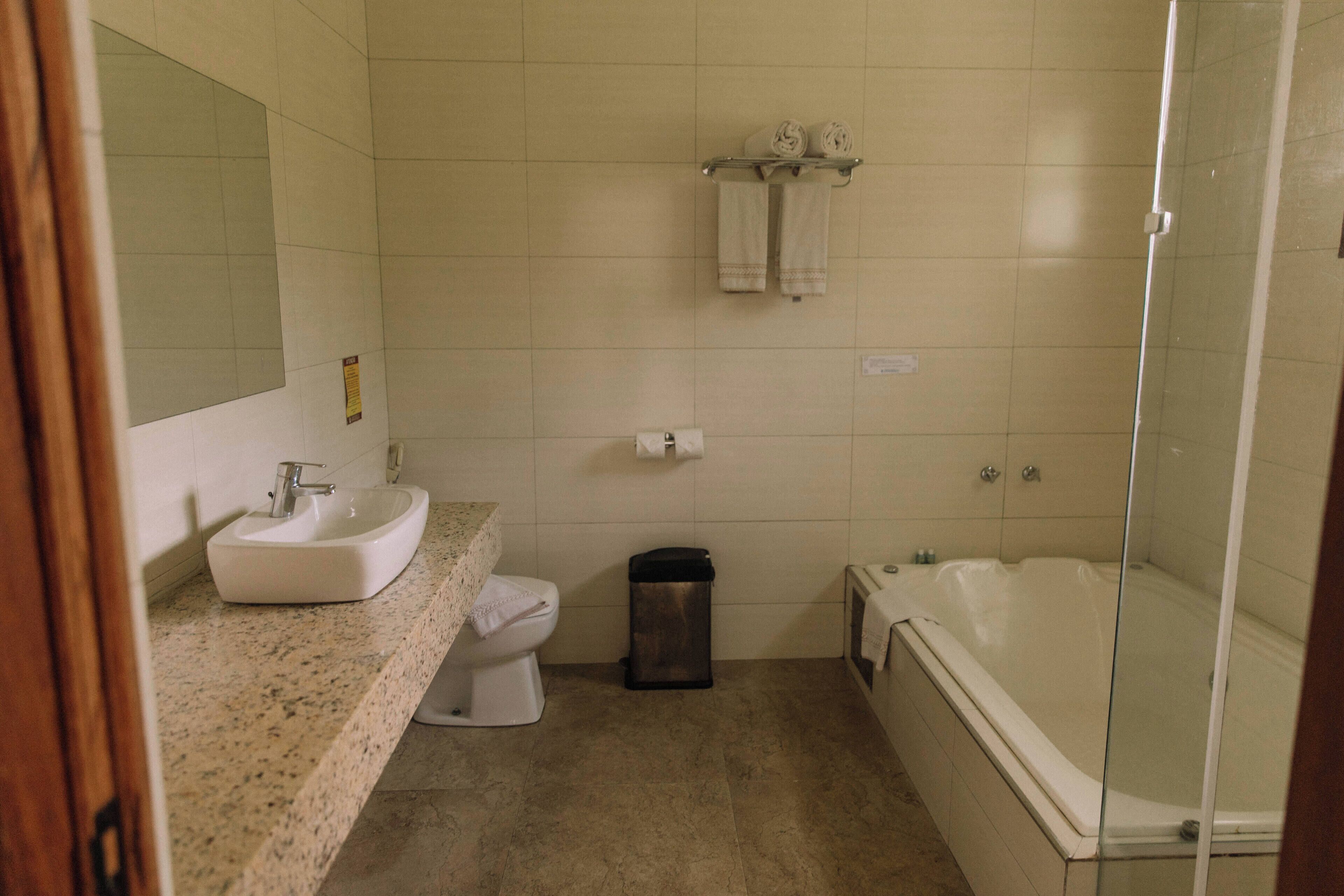 Een badkamer met een wastafel, toilet en bad.