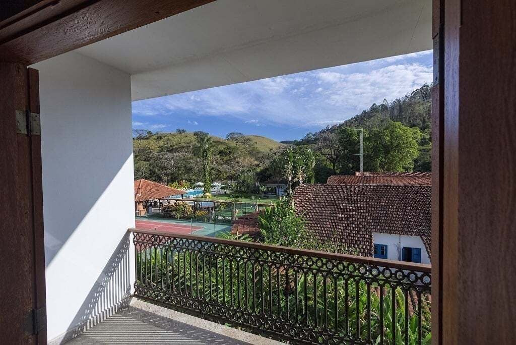 Un balcón con vistas a una zona residencial, con casas y vegetación.
