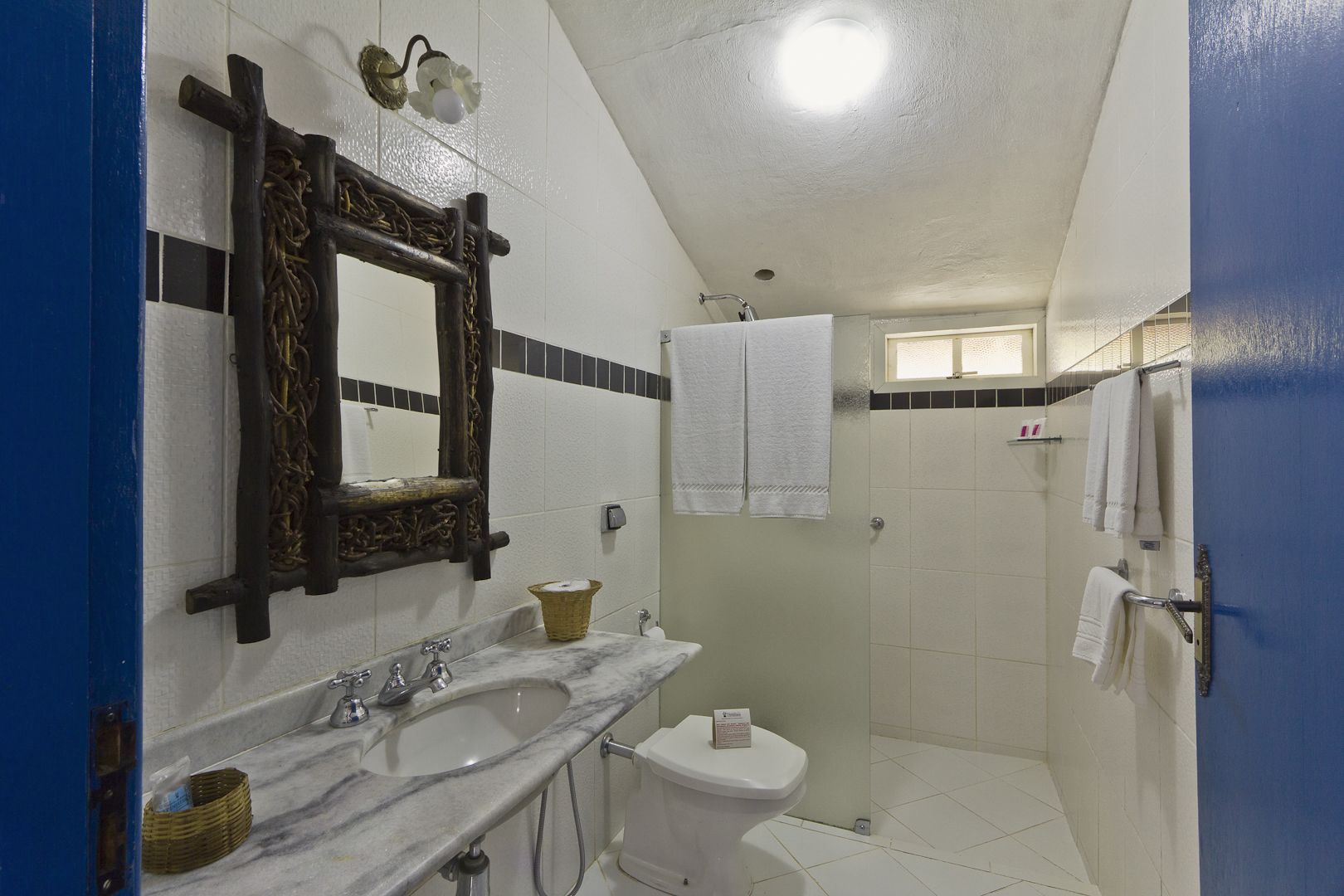 Casa de banho com lavatório de mármore, sanita e zona de duche.