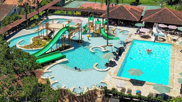 Ein Resort mit mehreren Schwimmbecken, einem Wasserpark und einer Bergkulisse.