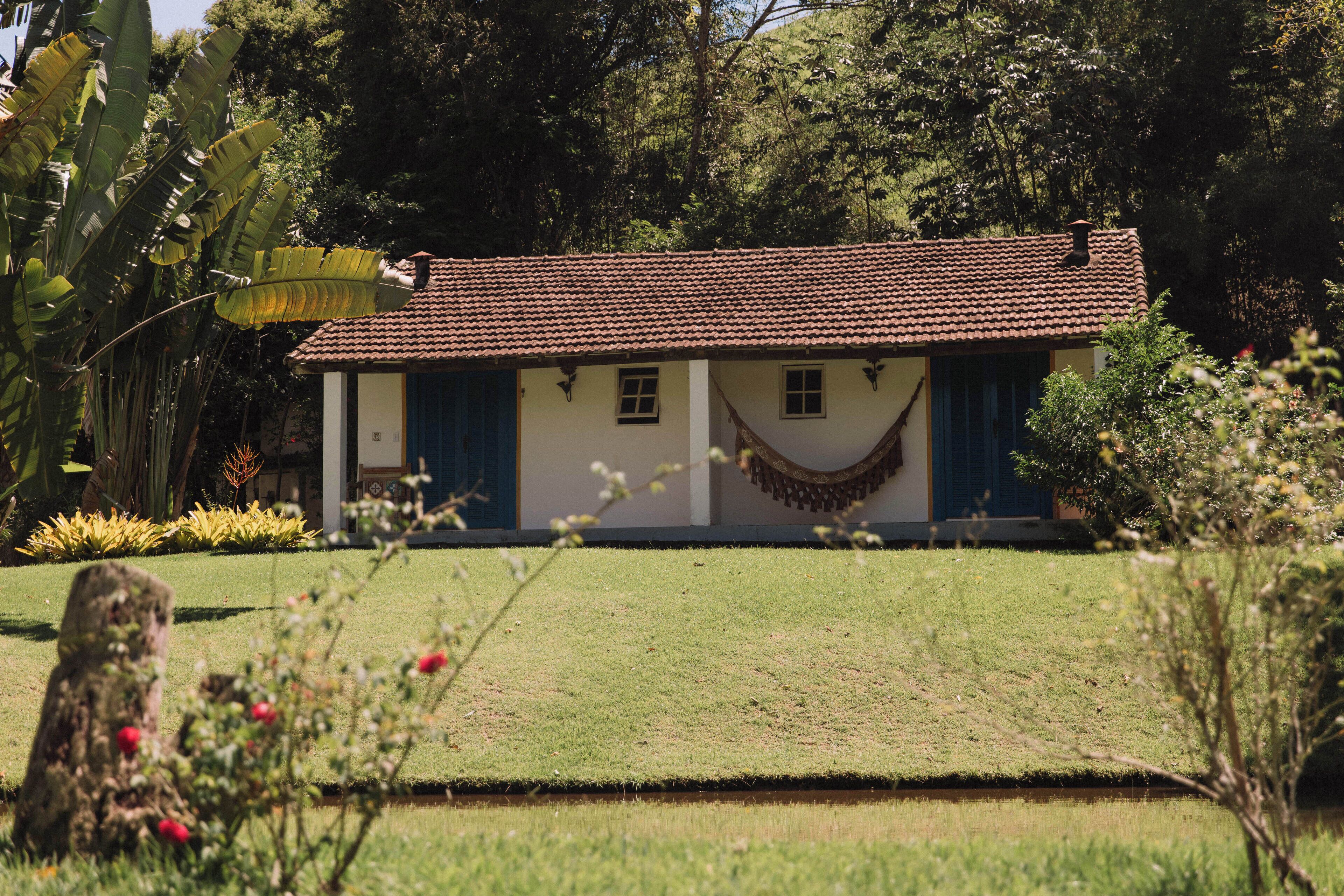 A single-story building with a tiled roof, surrounded by lush greenery and a well-maintained lawn.