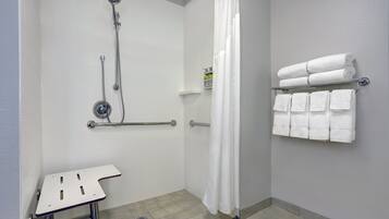 Un baño con ducha, inodoro y toallero.