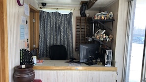 A small office with a wooden desk, computer, and shelves with various items. - Town Motel (Oshkosh)
